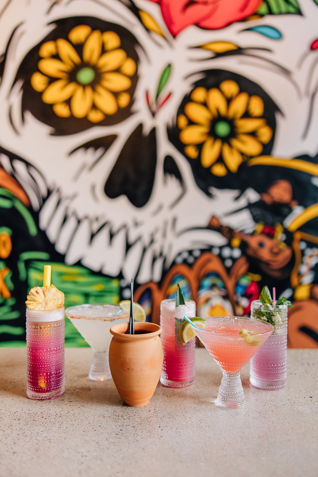 Specialty drinks on counter behind wall mural